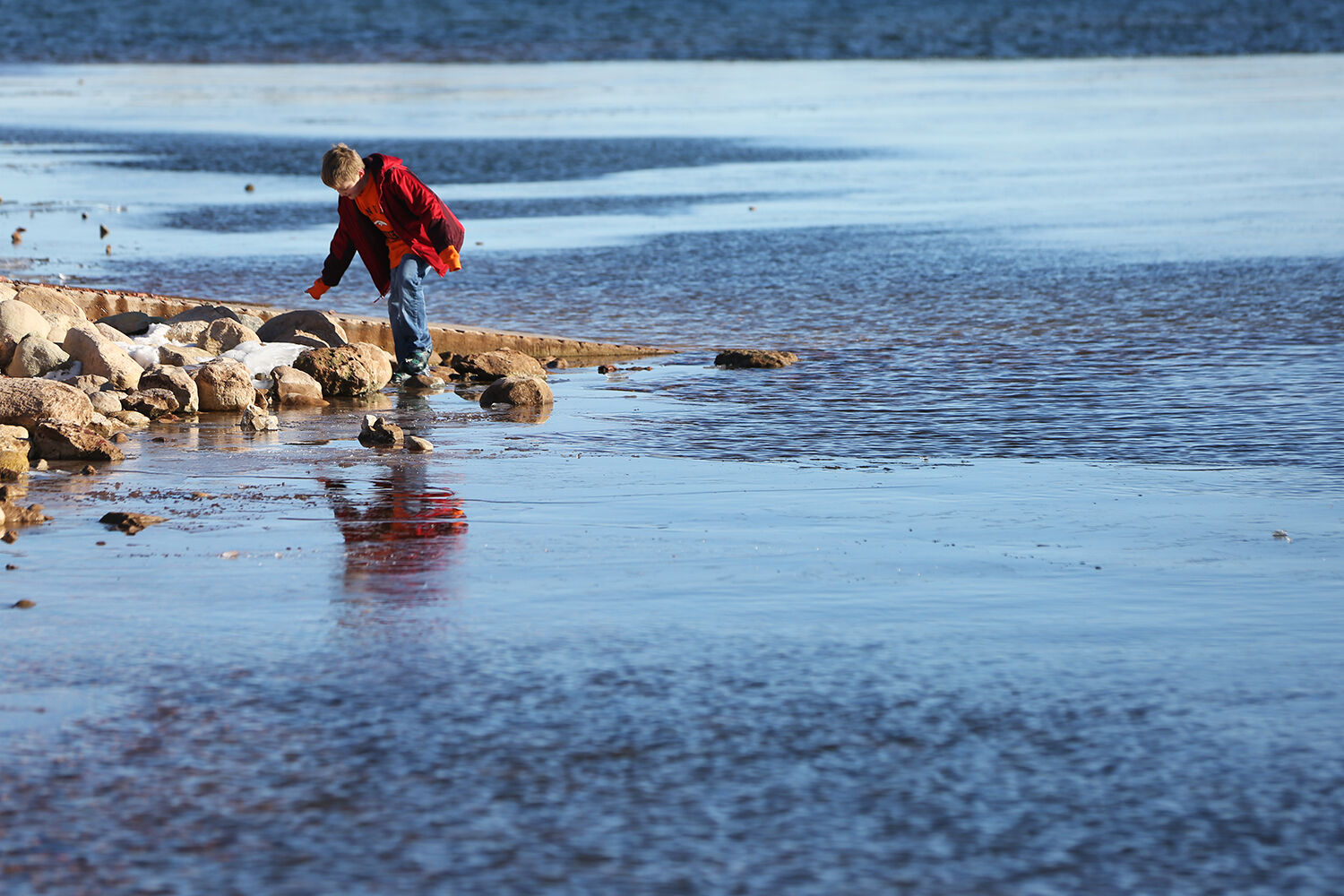 Joey Russell, 8, balances on the rocks near the boat dock